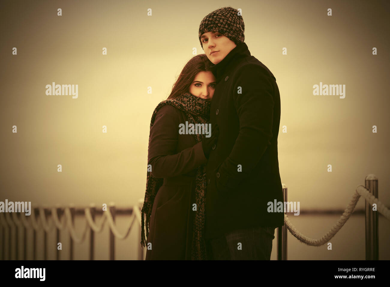 Felice coppia giovane in amore abbracciando outdoor elegante l uomo e la donna nel classico cappotti beanie e sciarpa Foto Stock