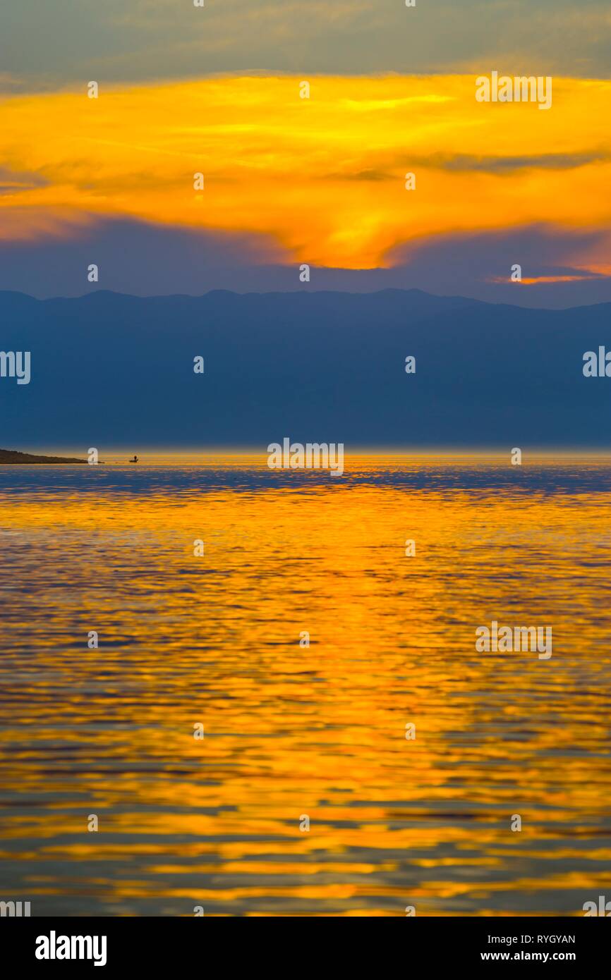 Tini fisherman barca da pesca di distanza nel tempo al tramonto Foto Stock