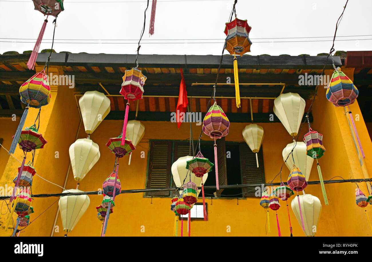 Tessuto colorato lanterne sospese tra una strada nel centro storico UNESCO di cui città vietnamita di Hoi An. Foto Stock