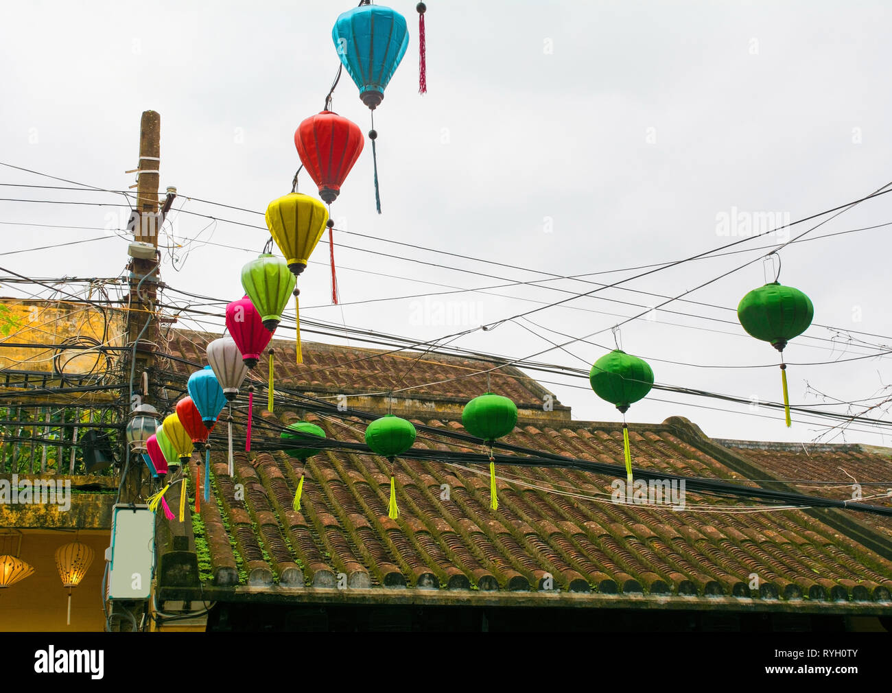 Tessuto colorato lanterne sospese tra una strada nel centro storico UNESCO di cui città vietnamita di Hoi An. Foto Stock