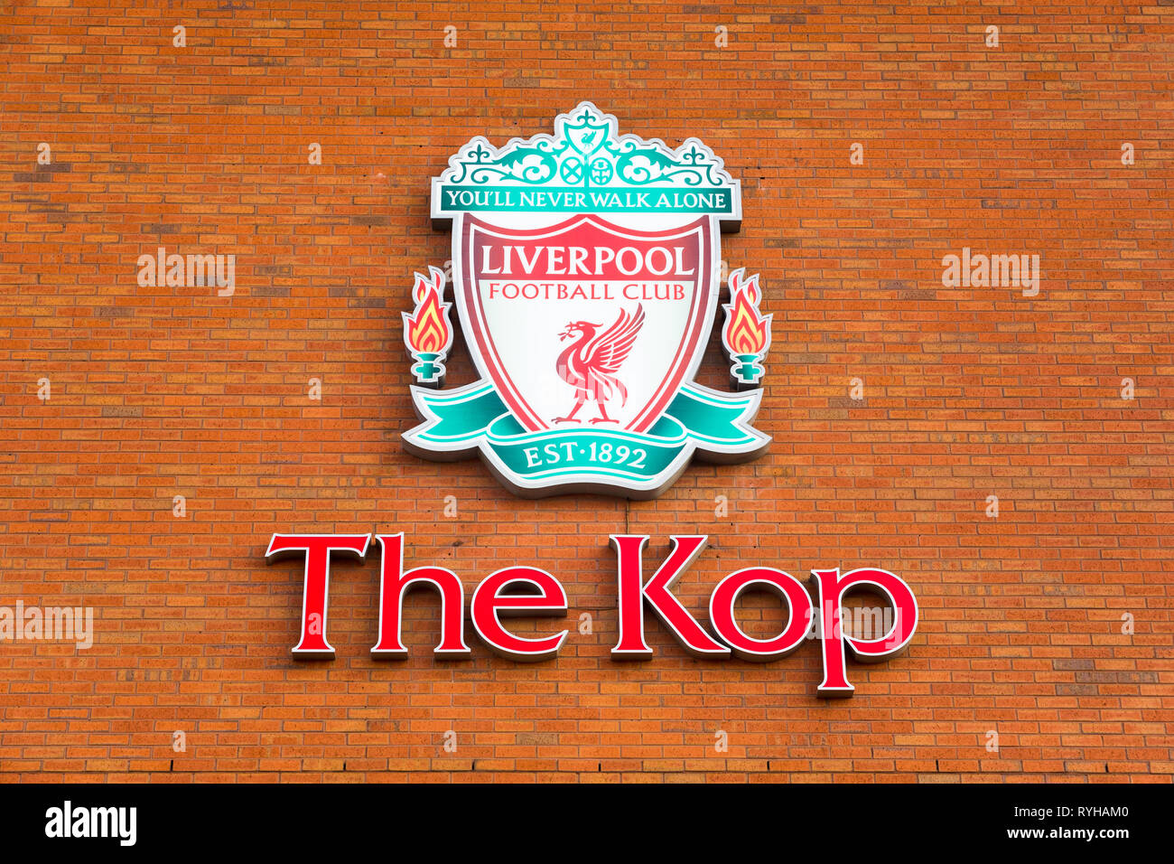 Grande rosso verde Liverpool Football Club Kop logo emblema distintivo segno montato su esterno muro di mattoni di Anfield Road Stadium rivolta Walton Breck Road Foto Stock