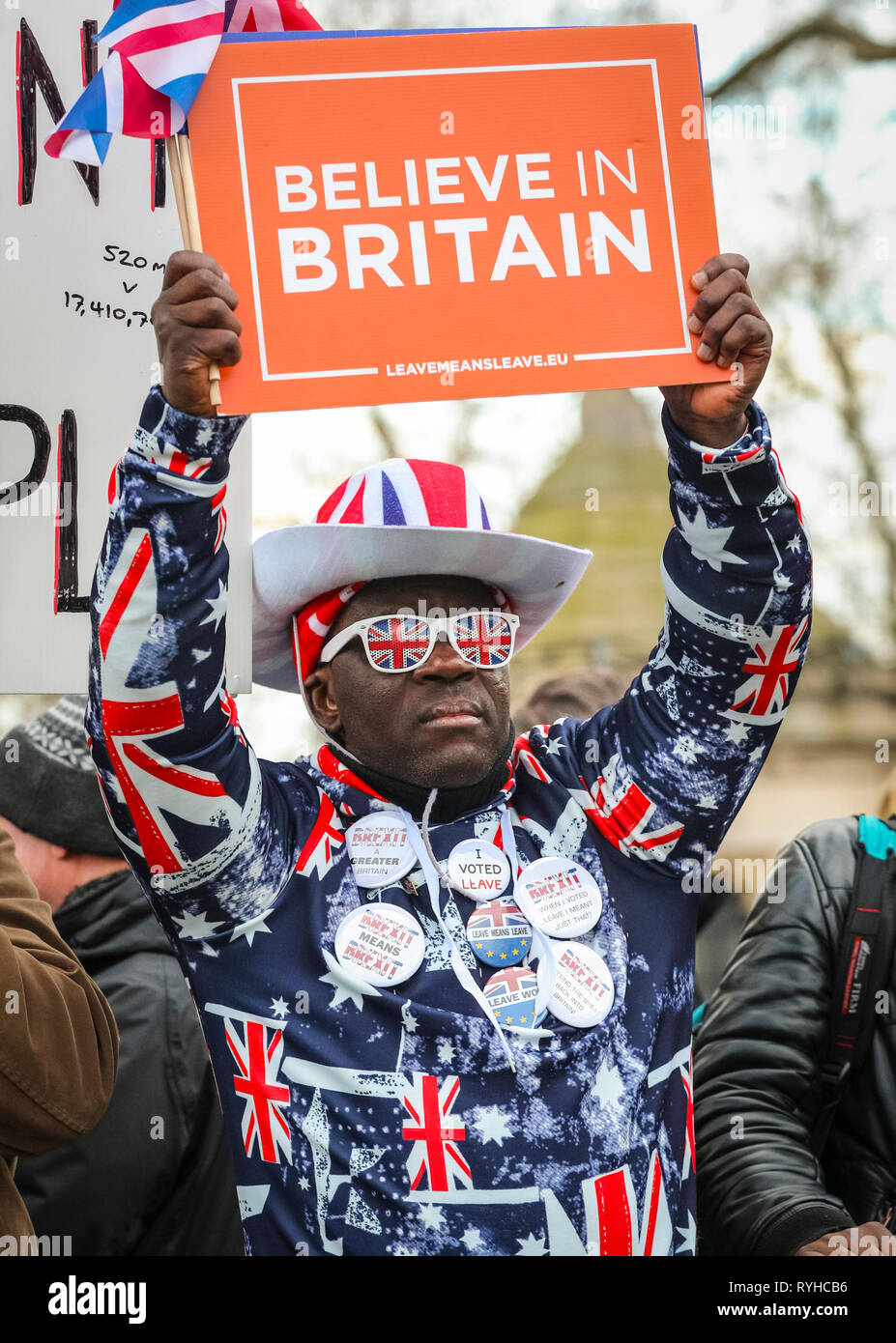 Westminster, Londra, Regno Unito. 13 Marzo 2019. Lasciare significa lasciare l'attivista e il protettore Joseph Afrane nel colorato vestito Union Jack. I manifestanti pro- e anti-Brexit si radunano fuori dalla Camera del Parlamento il giorno di un altro voto dei deputati sulla Brexit. Credit: Imageplotter/Alamy Live News Foto Stock