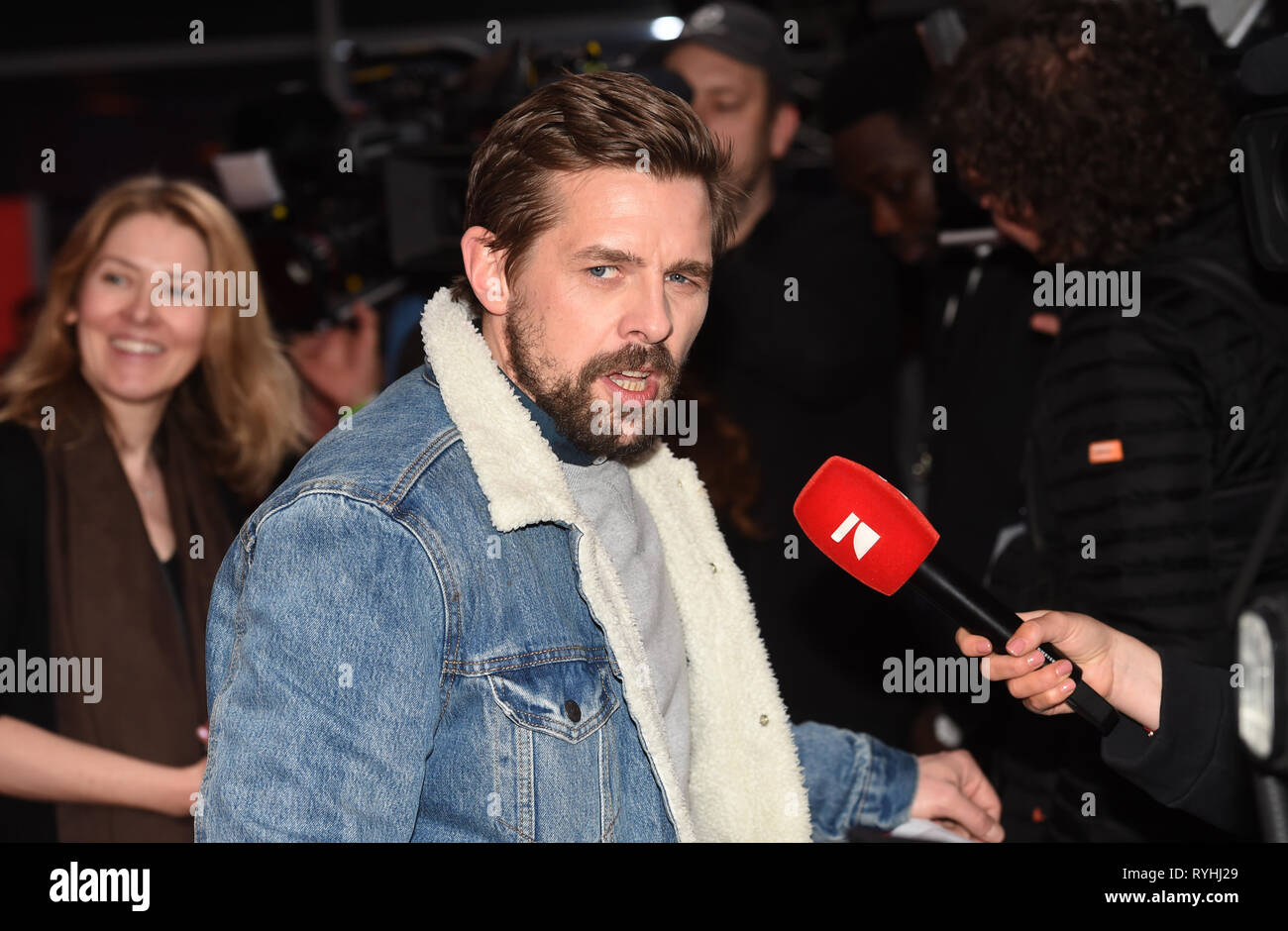 13 marzo 2019, il Land della Baviera, München: l'attore Klaas Heufer-Umlauf proviene per la premiere mondiale della commedia 'Die Goldfische' nell'Mathäser Kino e dà un'intervista per la stazione televisiva Pro 7. Foto: Felix Hörhager/dpa Foto Stock