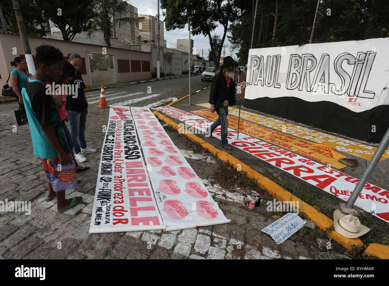 Sao Paulo, Brasile. Il 14 marzo 2019. Poster in omaggio alle vittime dell attacco sono visibili nella parte anteriore del Raul Brasil scuola statale, a Rua OtÃ¡vio Miguel da Silva, in Suzano, Sao Paulo, giovedì. Nella mattinata di ieri, mercoledì 13, due ragazzi incappucciati ha ucciso 8 persone all'interno della scuola e si è suicidato dopo. Almeno 11 altre persone sono state ferite. Parenti e amici delle vittime posto le candele e i fiori sul muro della scuola in memoria delle vittime dell'attentato. Marzo 14, 2019. Credito: FÃ¡Bio Vieira/FotoRua/ZUMA filo/Alamy Live News Foto Stock