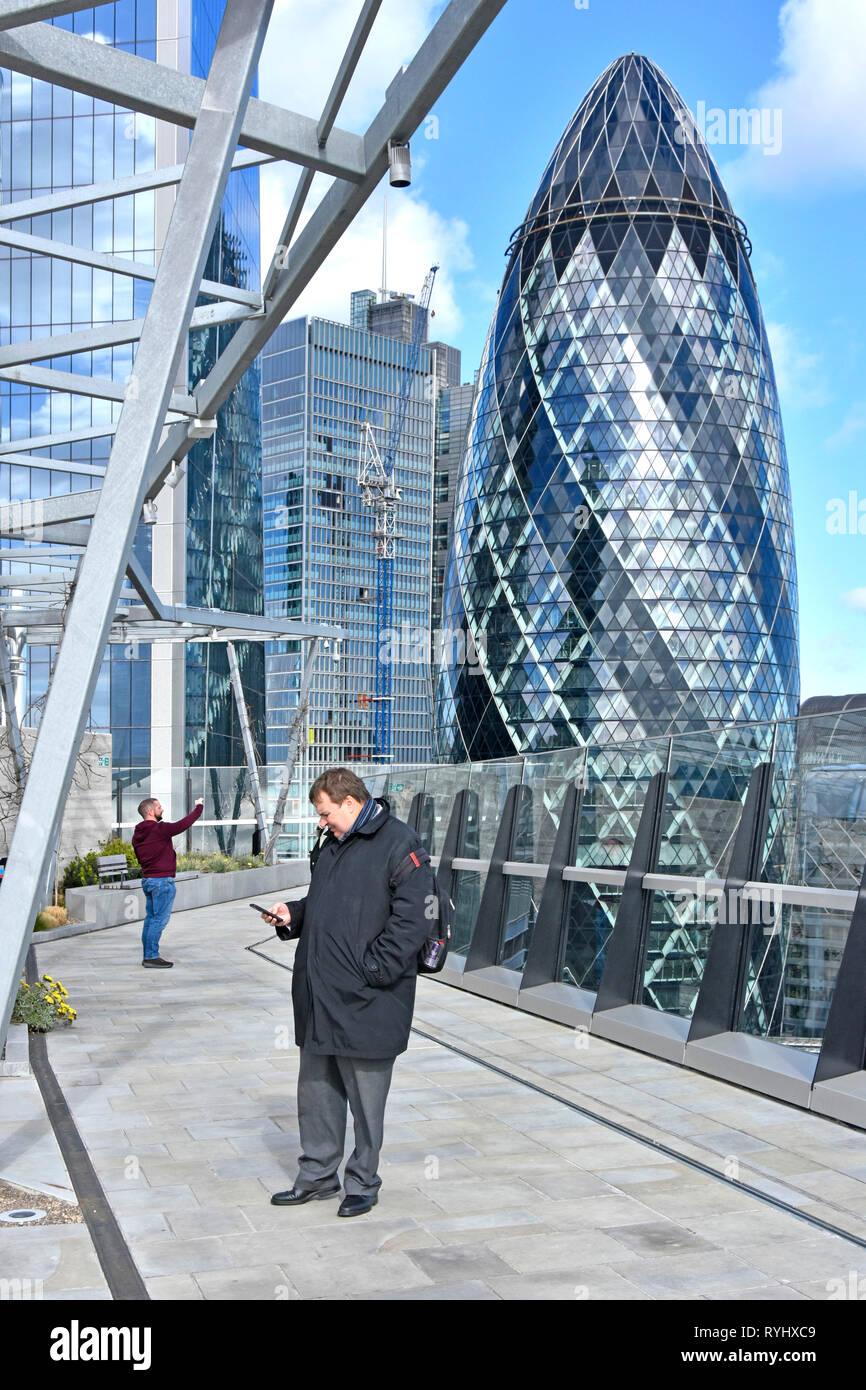 Cetriolino London city ufficio edificio dalla piattaforma di visualizzazione a Fen corte giardino sul tetto inverno uomini visitatori & mobile phone Fenchurch Street England Regno Unito Foto Stock