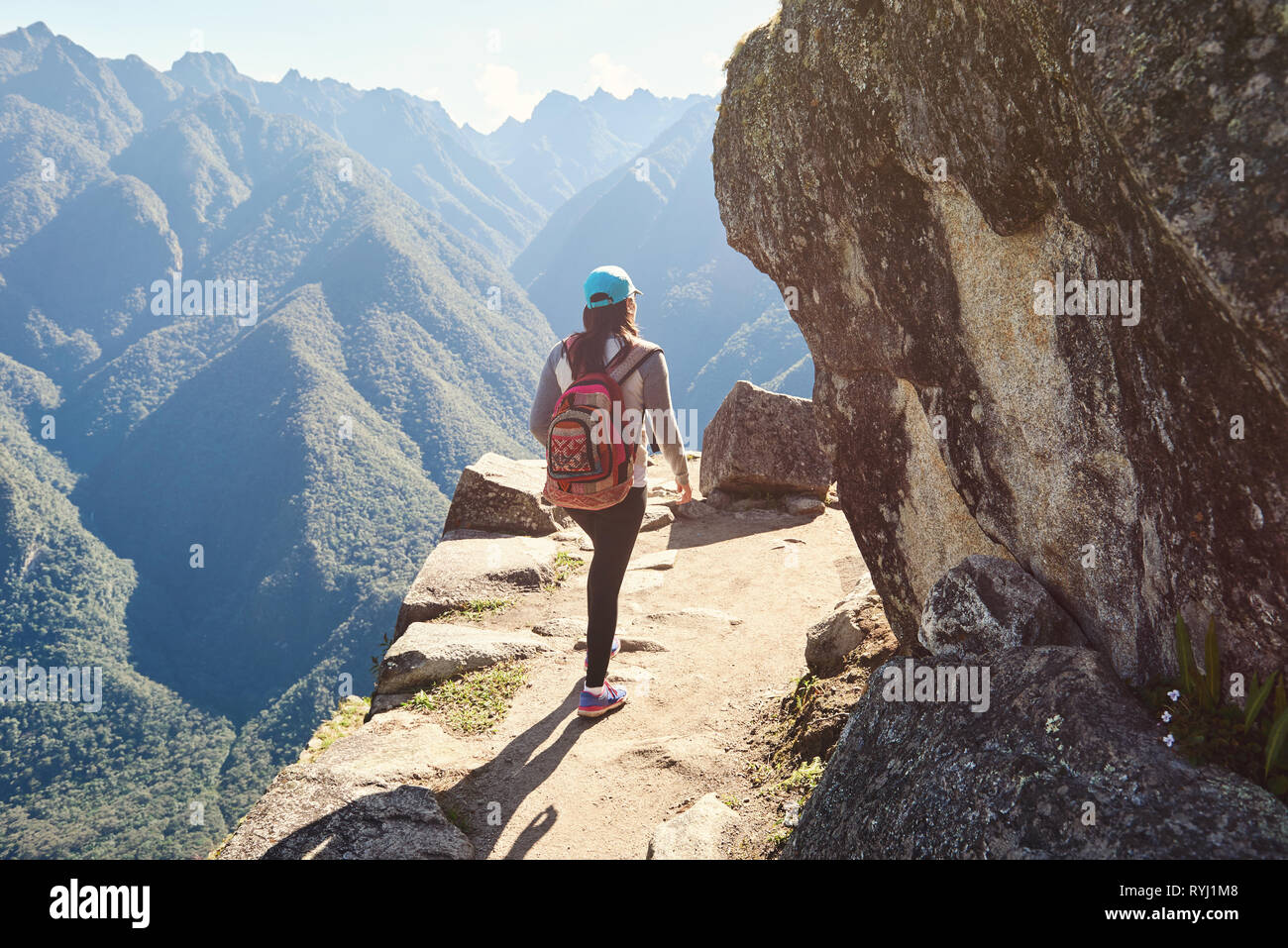 Donna passeggiata sulla scogliera di montagna vista posteriore Foto Stock