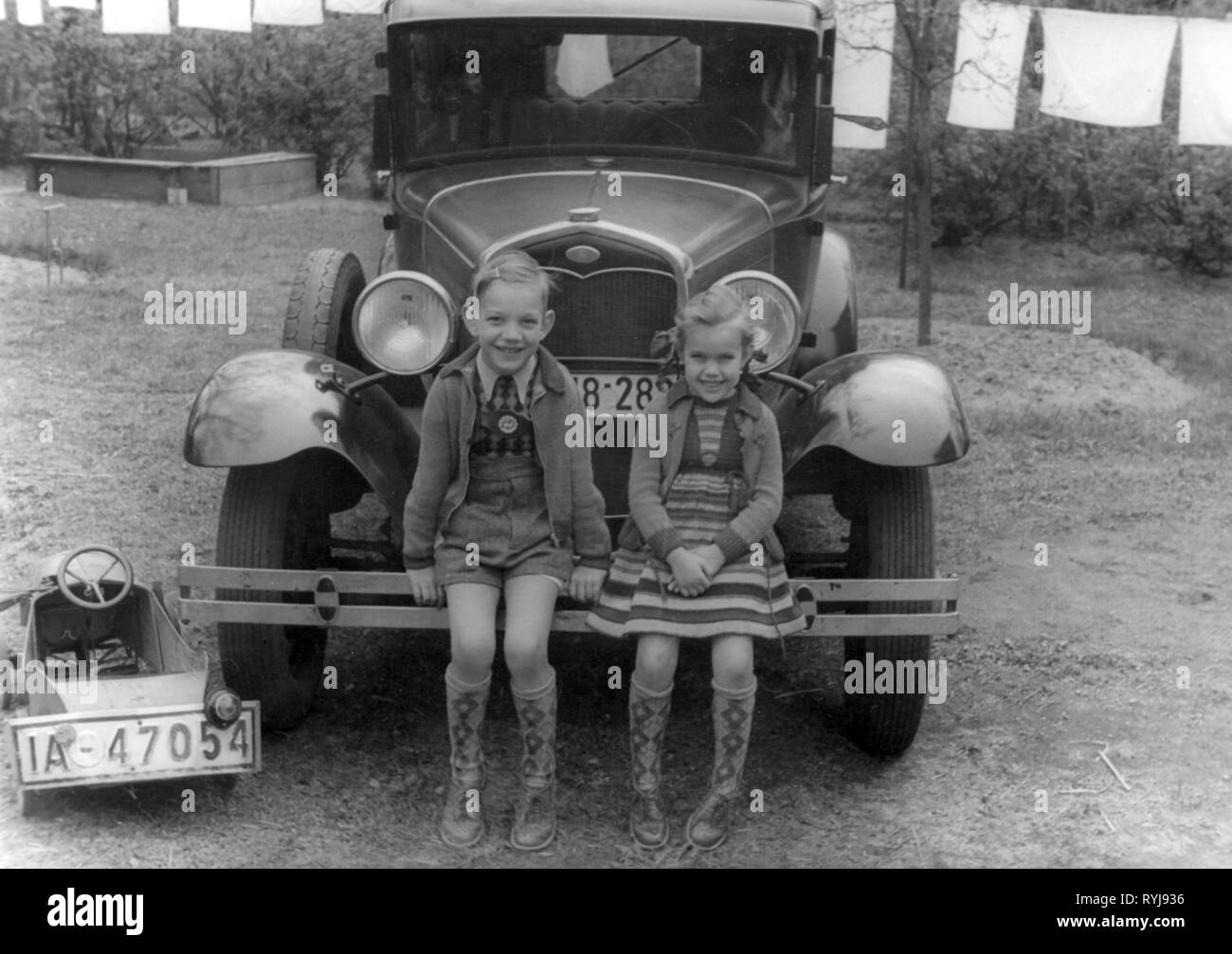 Persone, bambini, gruppo / fratelli - misti, un ragazzo e una ragazza seduta sul paraurti di un auto, Berlino, 1930, Additional-Rights-Clearance-Info-Not-Available Foto Stock