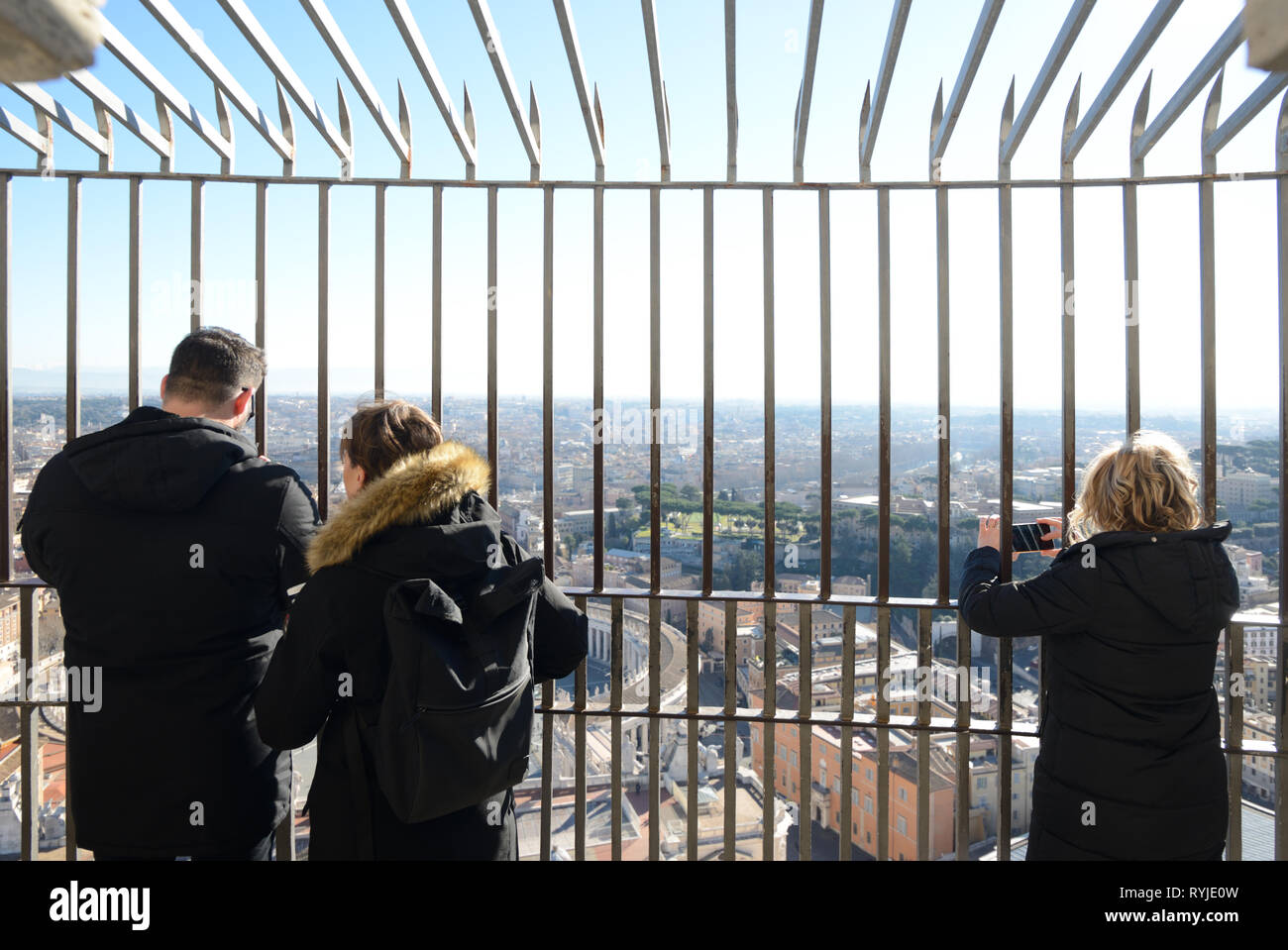 Tre turisti ammirando la vista dalla cima di Saint Peters Basilca cupola sopra Roma Italia Foto Stock