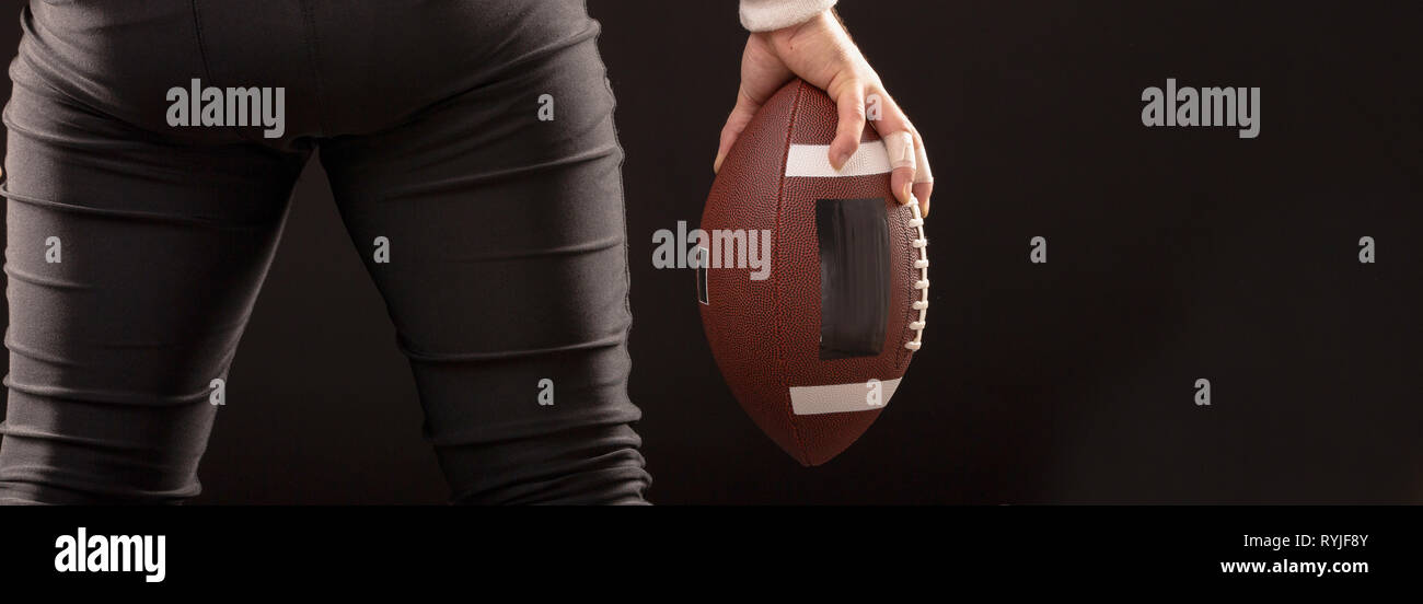 Immagine ritagliata di sportivo tenendo il football americano la sfera Foto Stock
