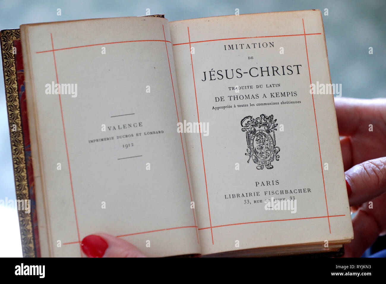La donna la lettura di un vecchio Libro Cristiano : imitazione de Gesù Cristo. Close-up. Foto Stock