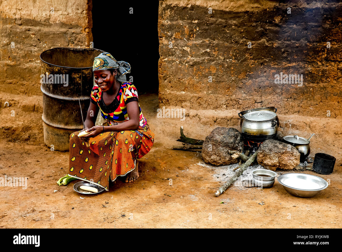 Ragazzo cucinando fuori la sua casa in un villaggio nei pressi di Daloa, Costa d'Avorio. Foto Stock