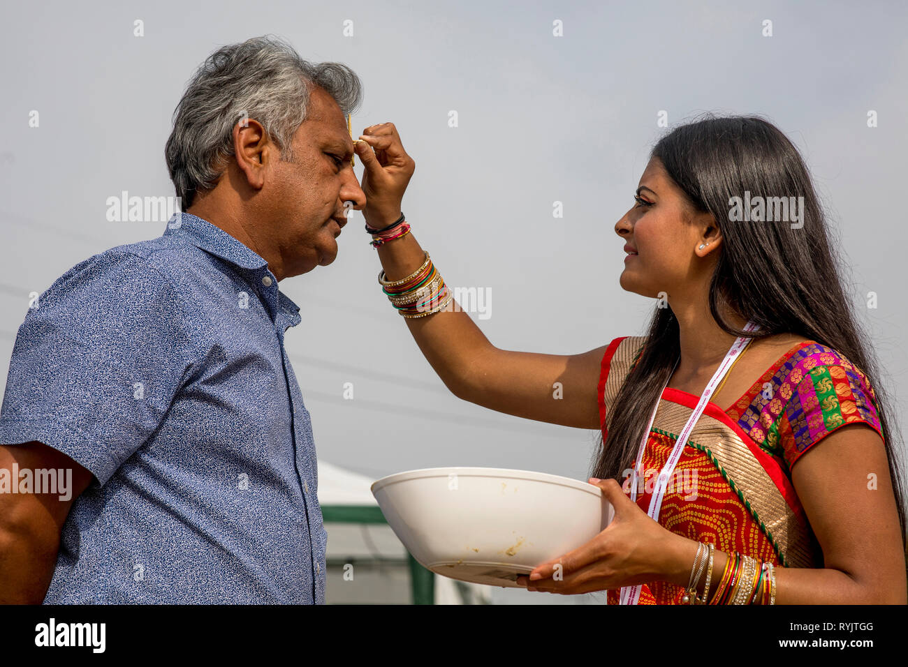 Messaggio di saluto in Janmashtami festival indù, Watford, Regno Unito Gli ospiti ricevono un marchio sulla loro fronte. Foto Stock