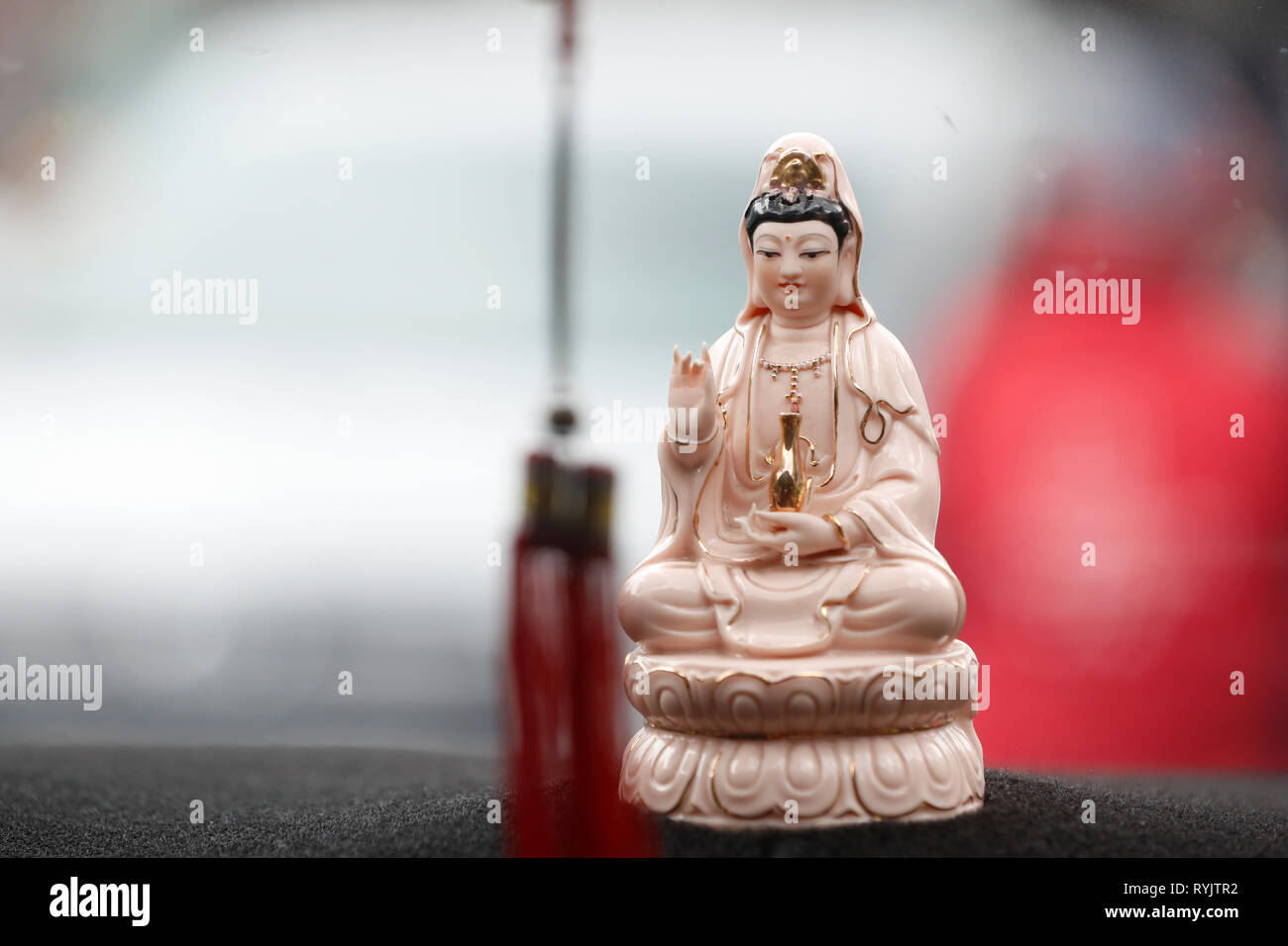 Quan Am, il Bodhisattva della compassione o della Dea della Misericordia. Talismano di protezione in un'auto. Ho Chi Minh City. Il Vietnam. Foto Stock