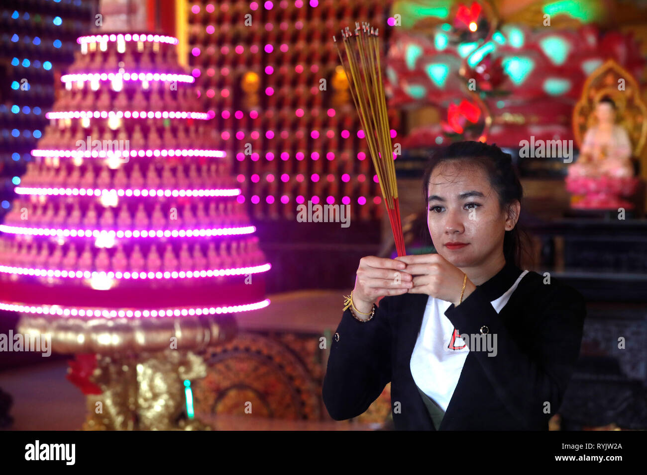 Huynh Dao pagoda buddista. Donna che prega il Buddha. Bastoncini di incenso. Chau Doc. Il Vietnam. Foto Stock