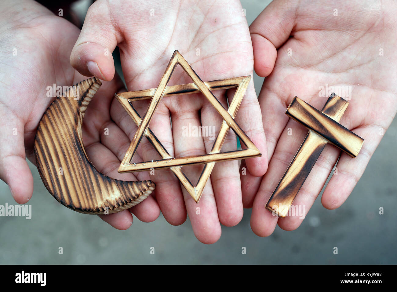 Il cristianesimo, islam ebraismo 3 religioni monoteiste. Stella ebraica, Croce e Crescent : interreligioso di simboli nelle mani. Foto Stock