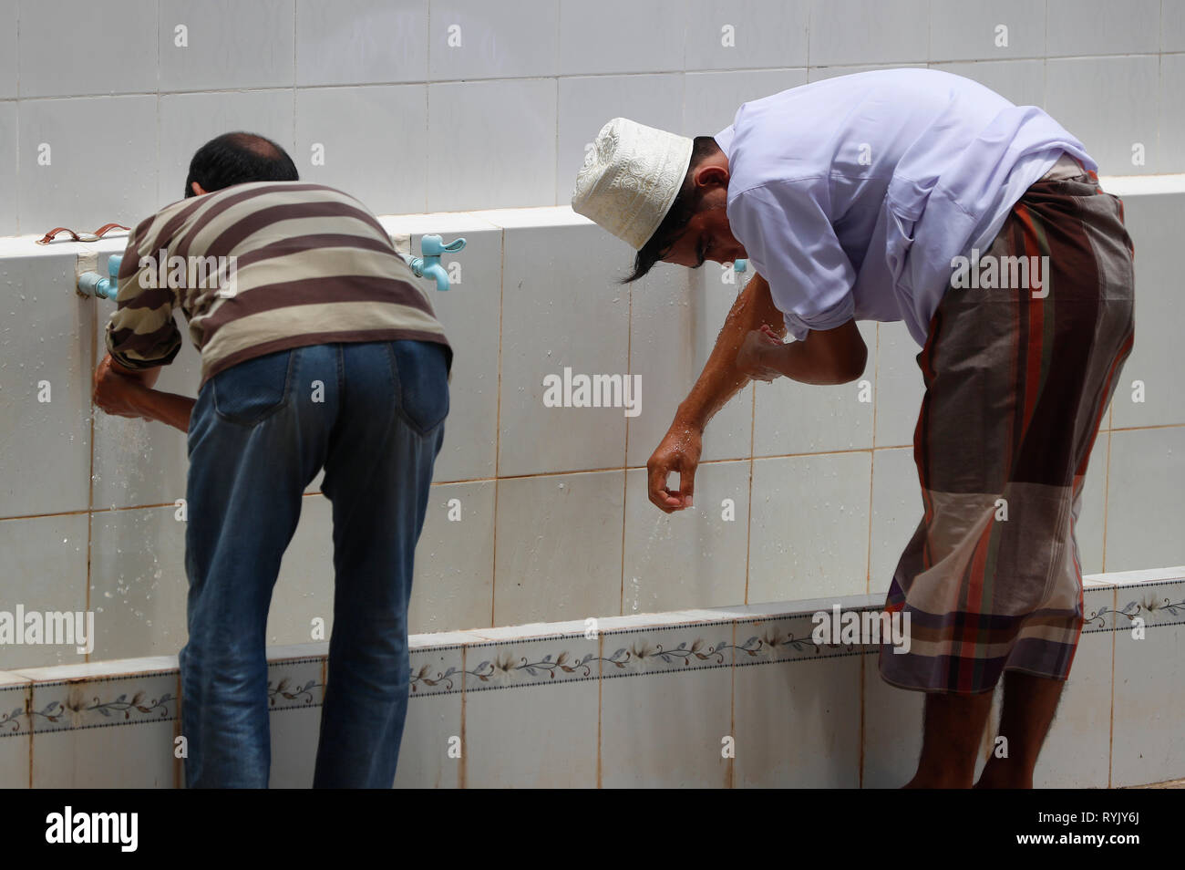 Masjid moschea Ar-Rohmah. Gli uomini di eseguire abluzione prima di pregare. Chau Doc. Il Vietnam. Foto Stock