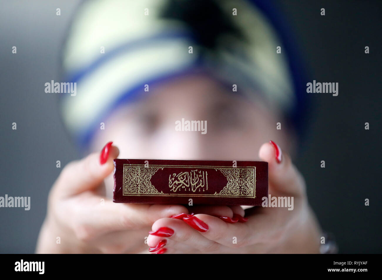Donna musulmana tenendo premuto il Sacro Corano il libro. Foto Stock