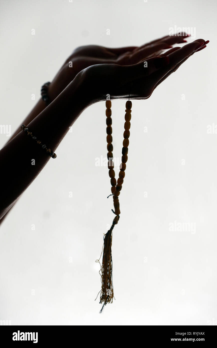 Donna musulmana holding preghiera islamica perle. Foto Stock