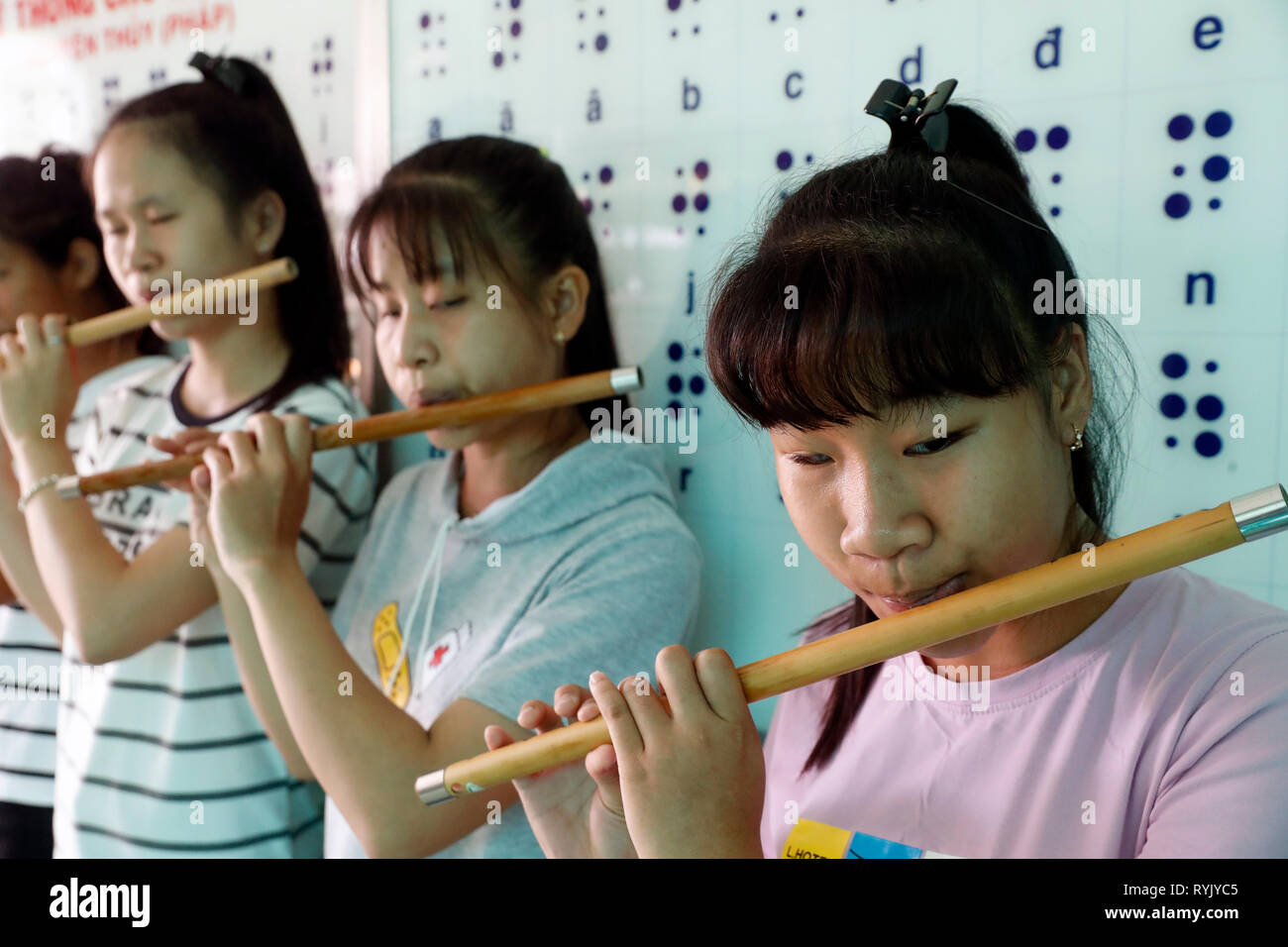Centro per i bambini ciechi gestito da bambini azione. Le giovani ragazze la riproduzione di musica. Ho Chi Minh city. Il Vietnam. Foto Stock