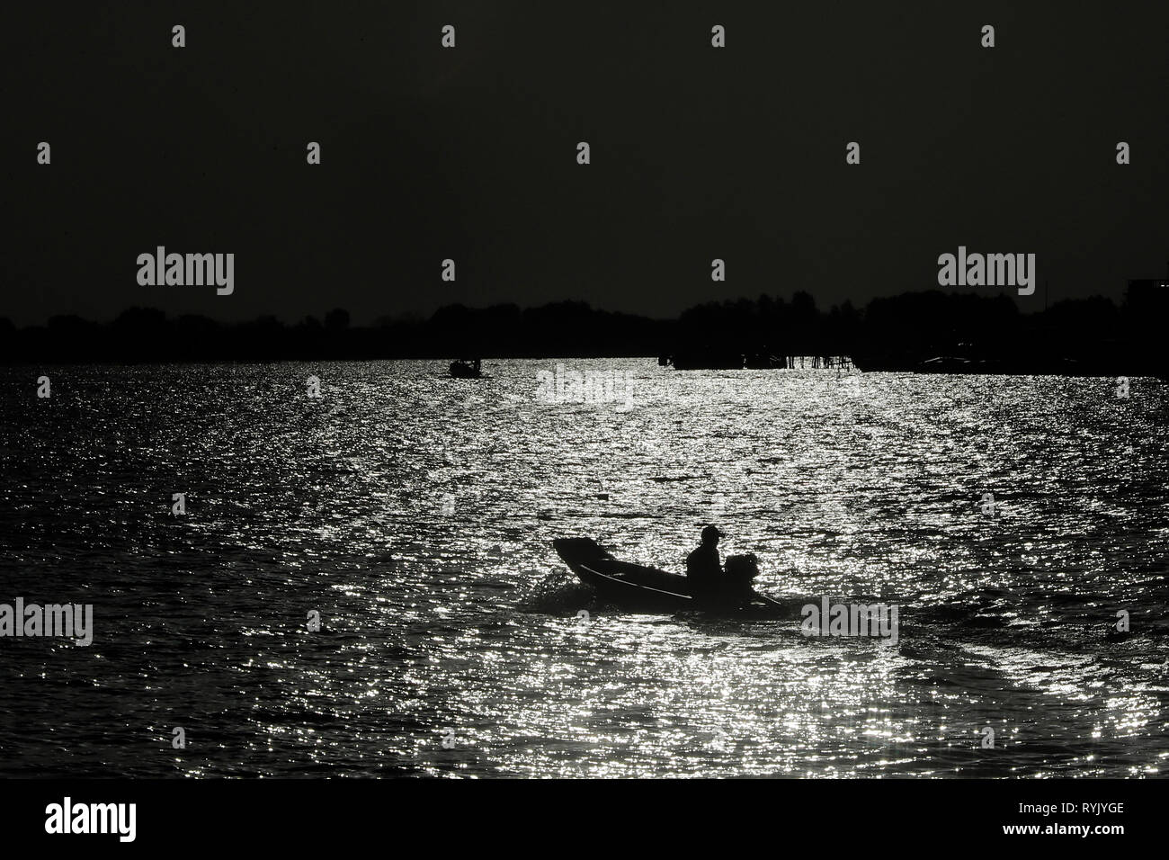 Barca dalla coda lunga al tramonto. Ha Tien. Il Vietnam. Foto Stock