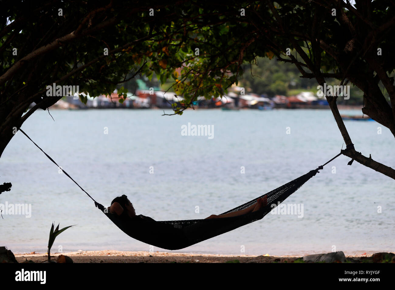 Sul mare del sud della Cina. Donna relax su una spiaggia in un'amaca. Ha Tien. Il Vietnam. Foto Stock