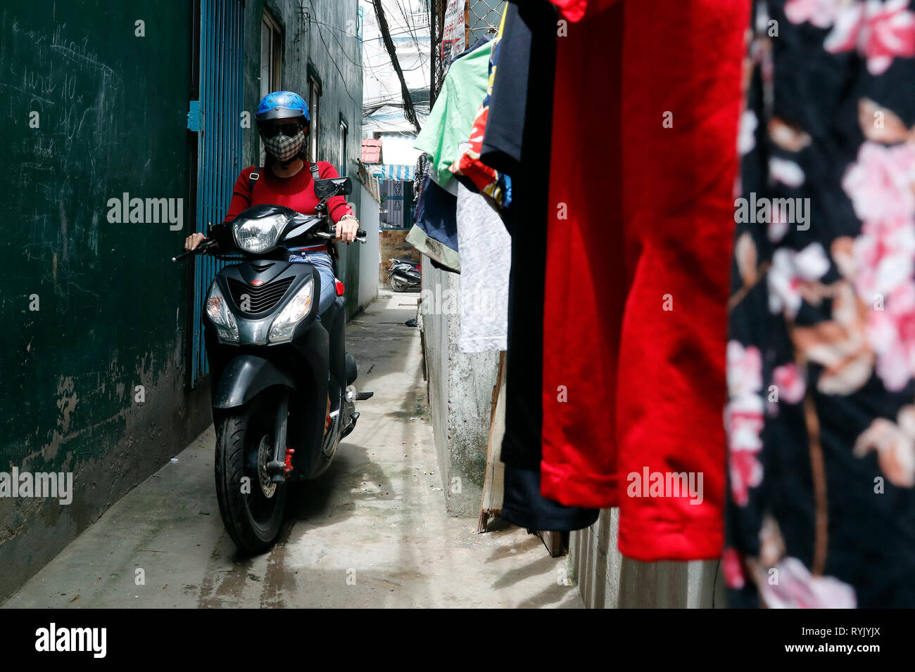 Donna alla guida di moto sulla piccola strada. Ho Chi Minh City. Il Vietnam. Foto Stock