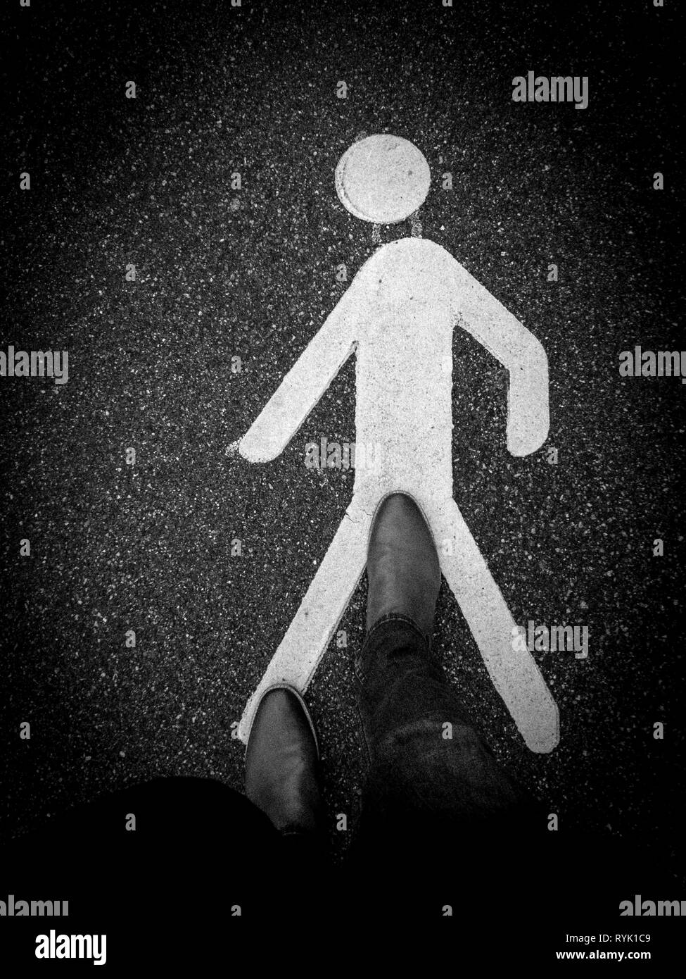 Segnale pedonale sul marciapiede con piedini Foto Stock
