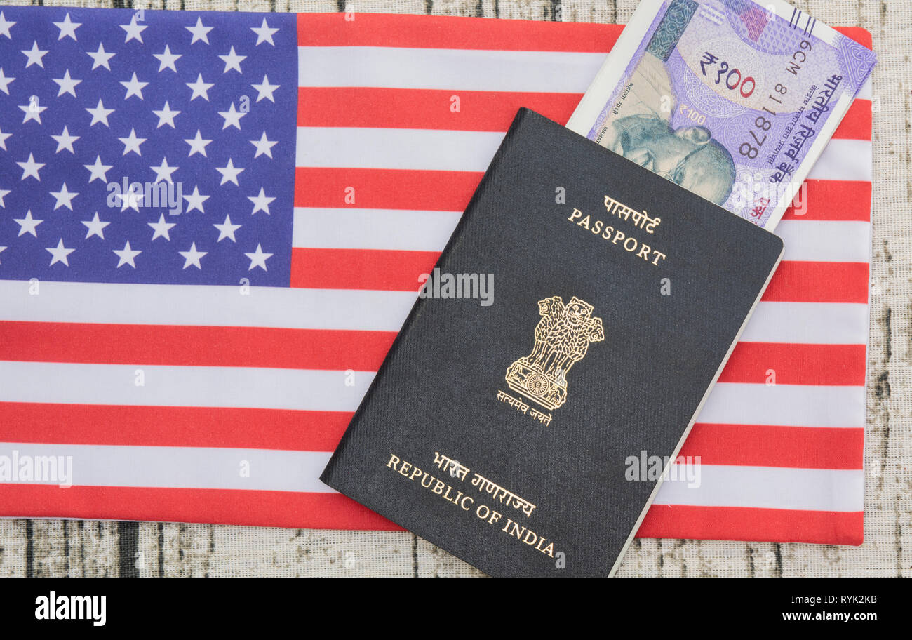 Passaporto indiano con valuta in USA o in america la bandiera come sfondo Foto Stock