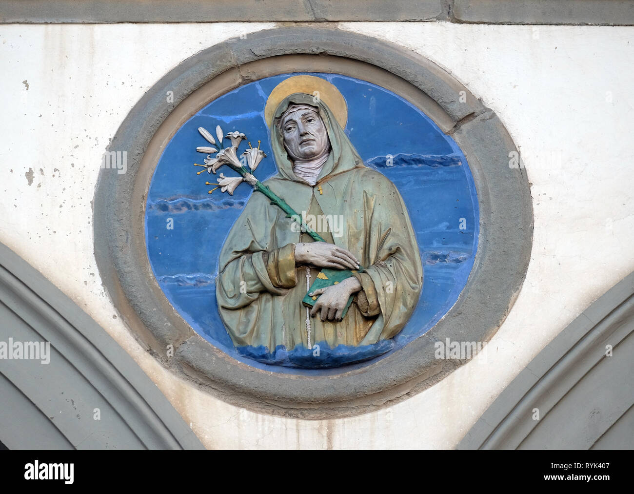 Santa Chiara, vetrato tondo in terracotta di Andrea della Robbia, situata tra due archi del vecchio Ospedale di San Paolo, a Firenze, Italia Foto Stock