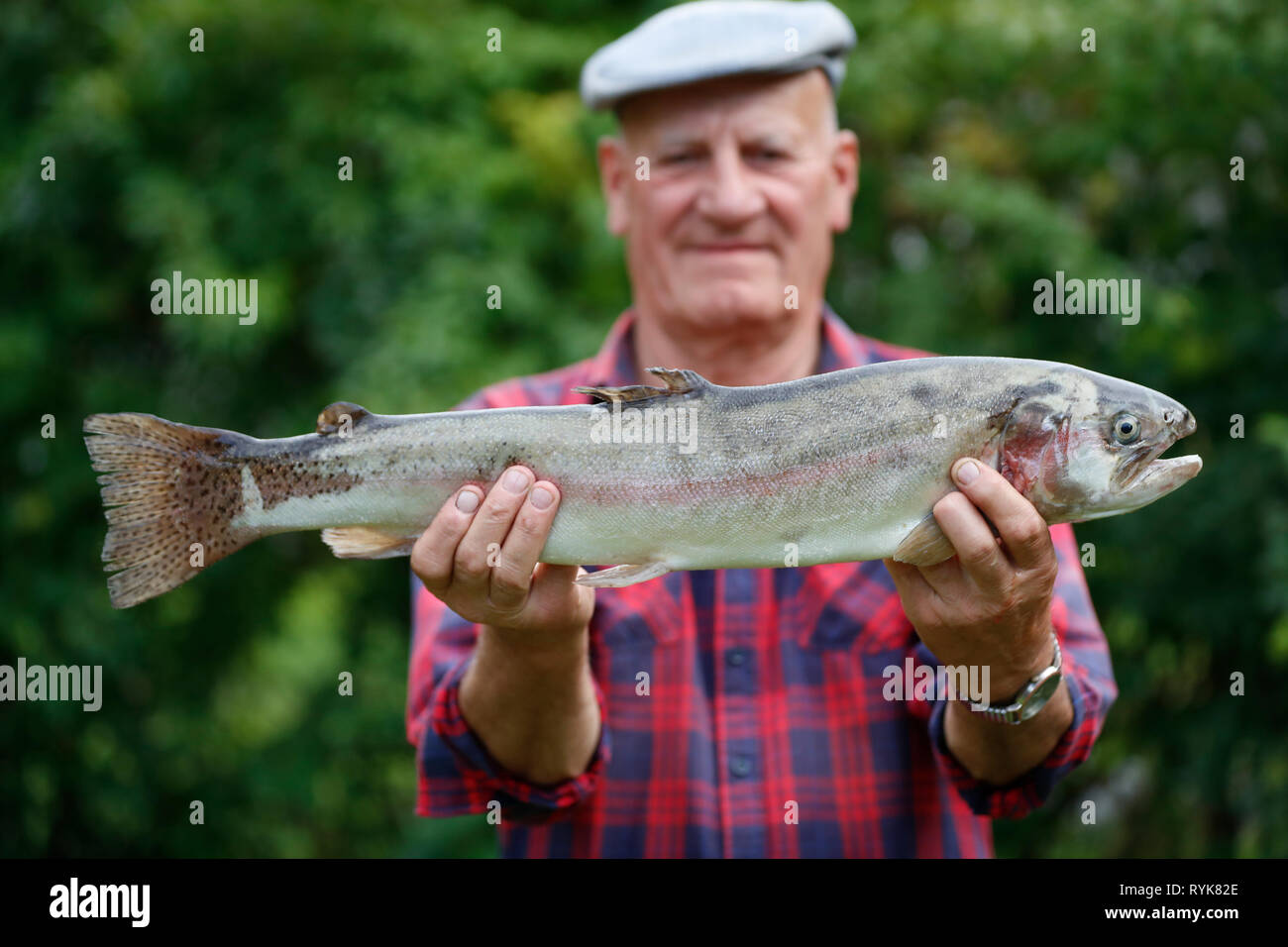 Pescatore con una grande trota pescata in un lago. La Francia. Foto Stock