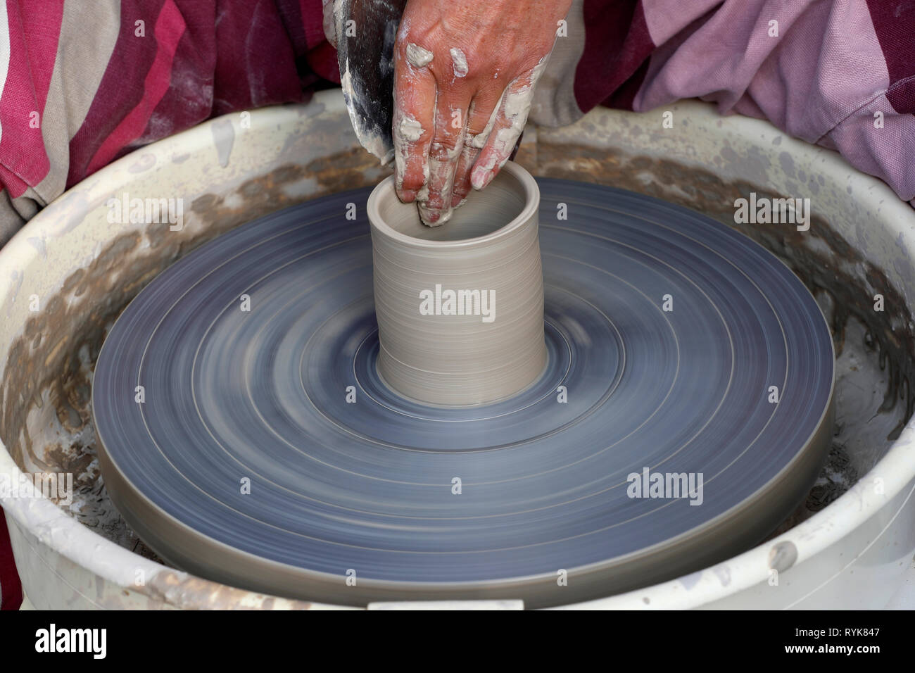 Vecchio Domancy craft festival. Le mani di un vasaio argilla di sagomatura in corrispondenza di una ruota di vasai. La Francia. Foto Stock