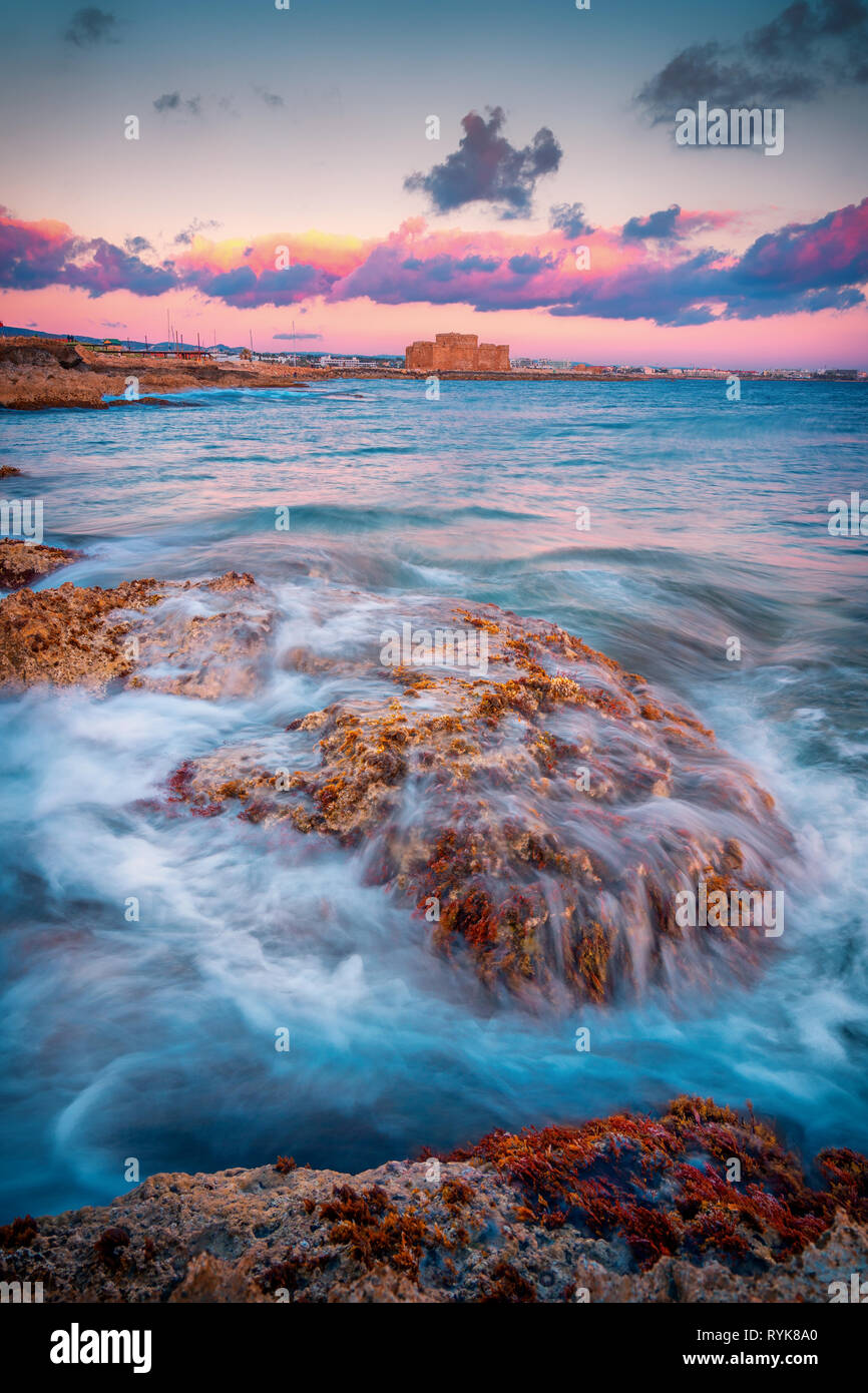 Bella lunga esposizione tramonto colpo di un paesaggio marino vista di Paphos il castello medievale e il mare Foto Stock