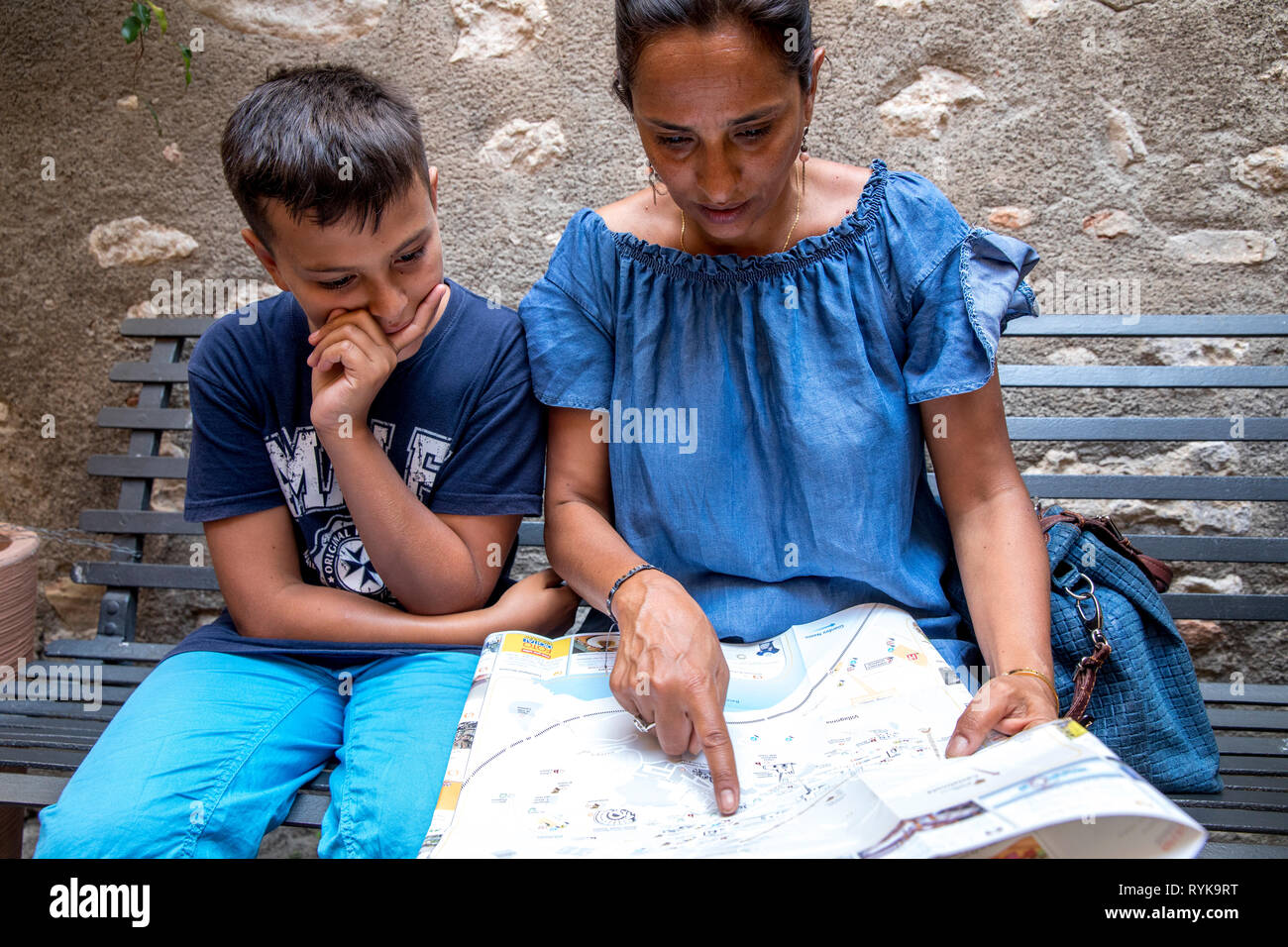 Madre e figlio guardando una mappa di Taormina, Sicilia (Italia). Foto Stock