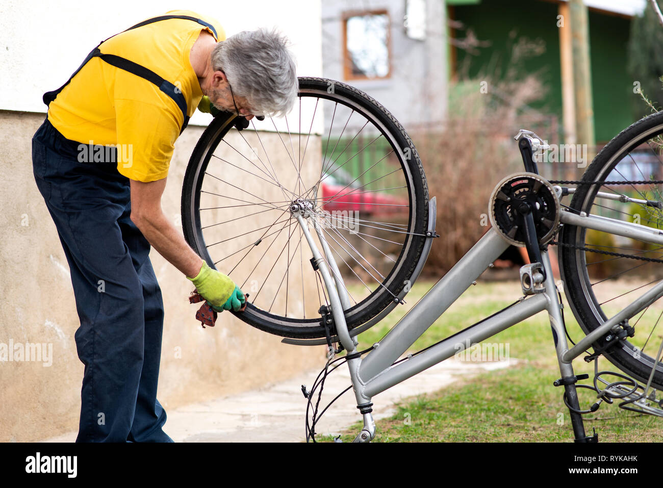 Uomo che pulisce la sua bicicletta per la nuova stagione di guida Foto Stock
