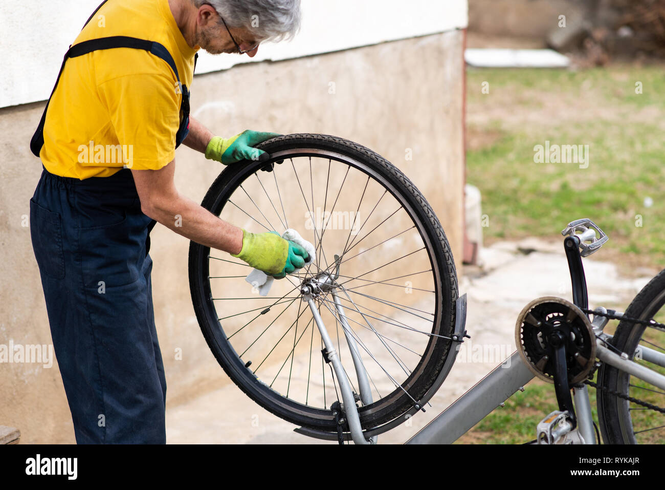 Uomo che pulisce la sua bicicletta per la nuova stagione di guida Foto Stock