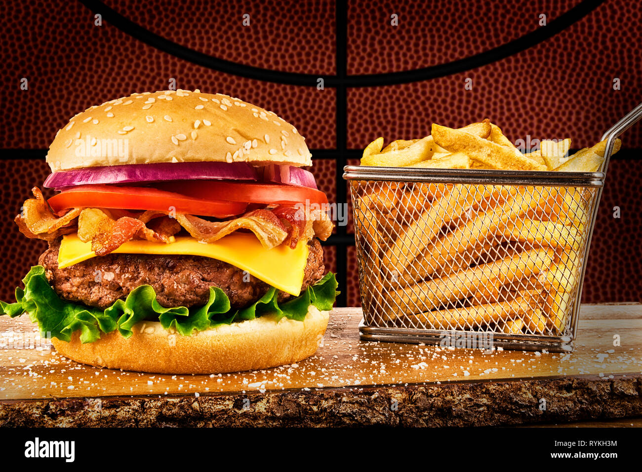 Cheeseburger con pancetta e un cestino di patatine fritte. Il basket ball immagine in background. Foto Stock