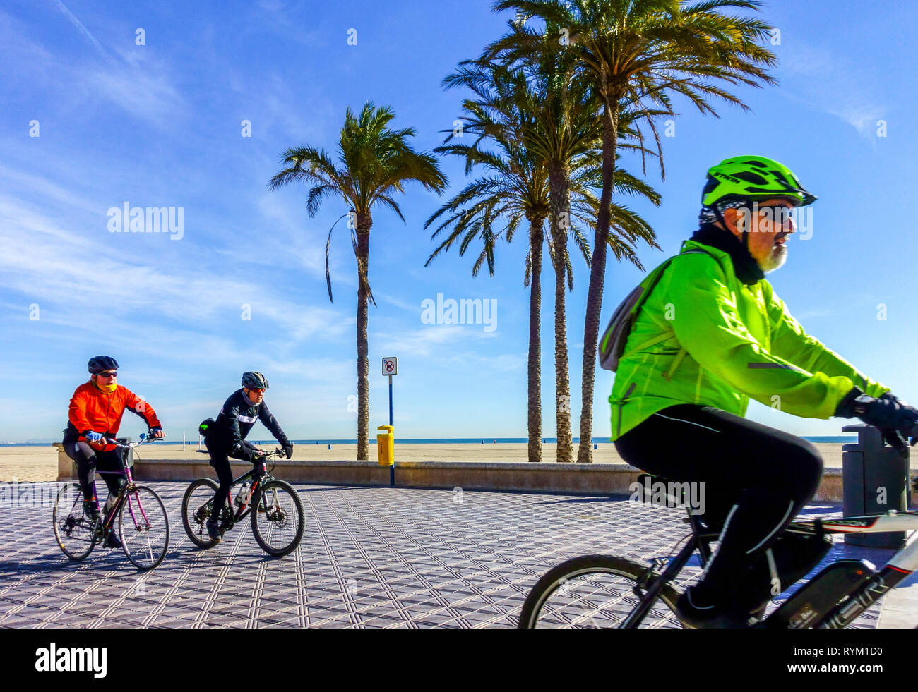 Valencia spiaggia di Malvarrosa, persone in bicicletta sulla spiaggia, El Cabanyal barrio, Spagna Foto Stock