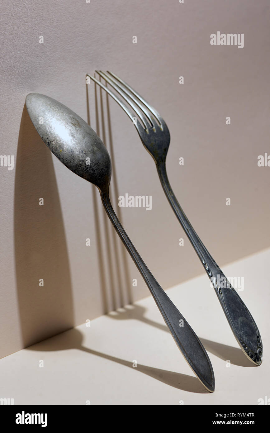Concetto di argento cucchiaio e forchetta sulla parete Foto Stock