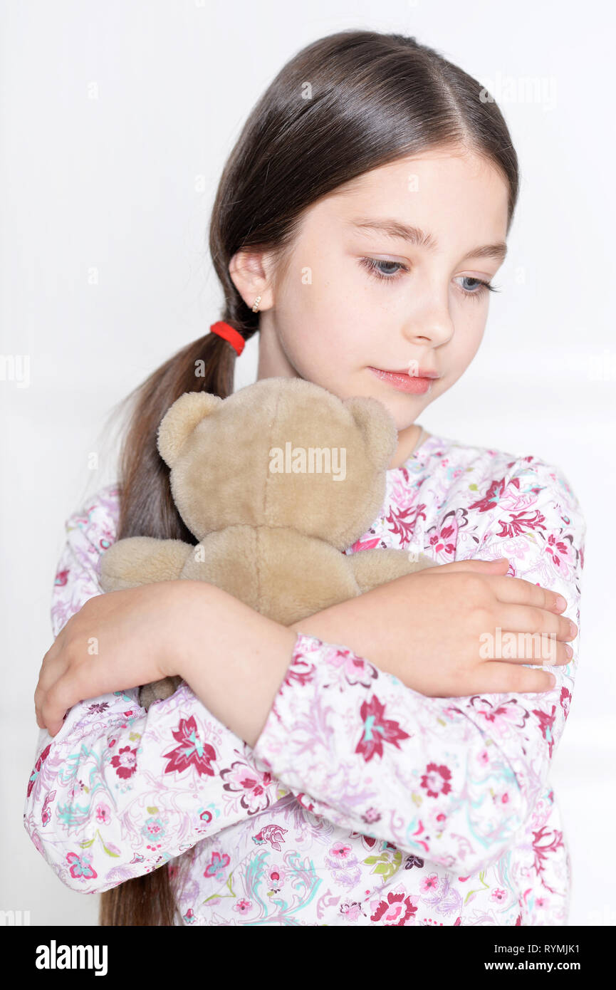 Carino bambina in posa con Teddy cordone in studio Foto Stock