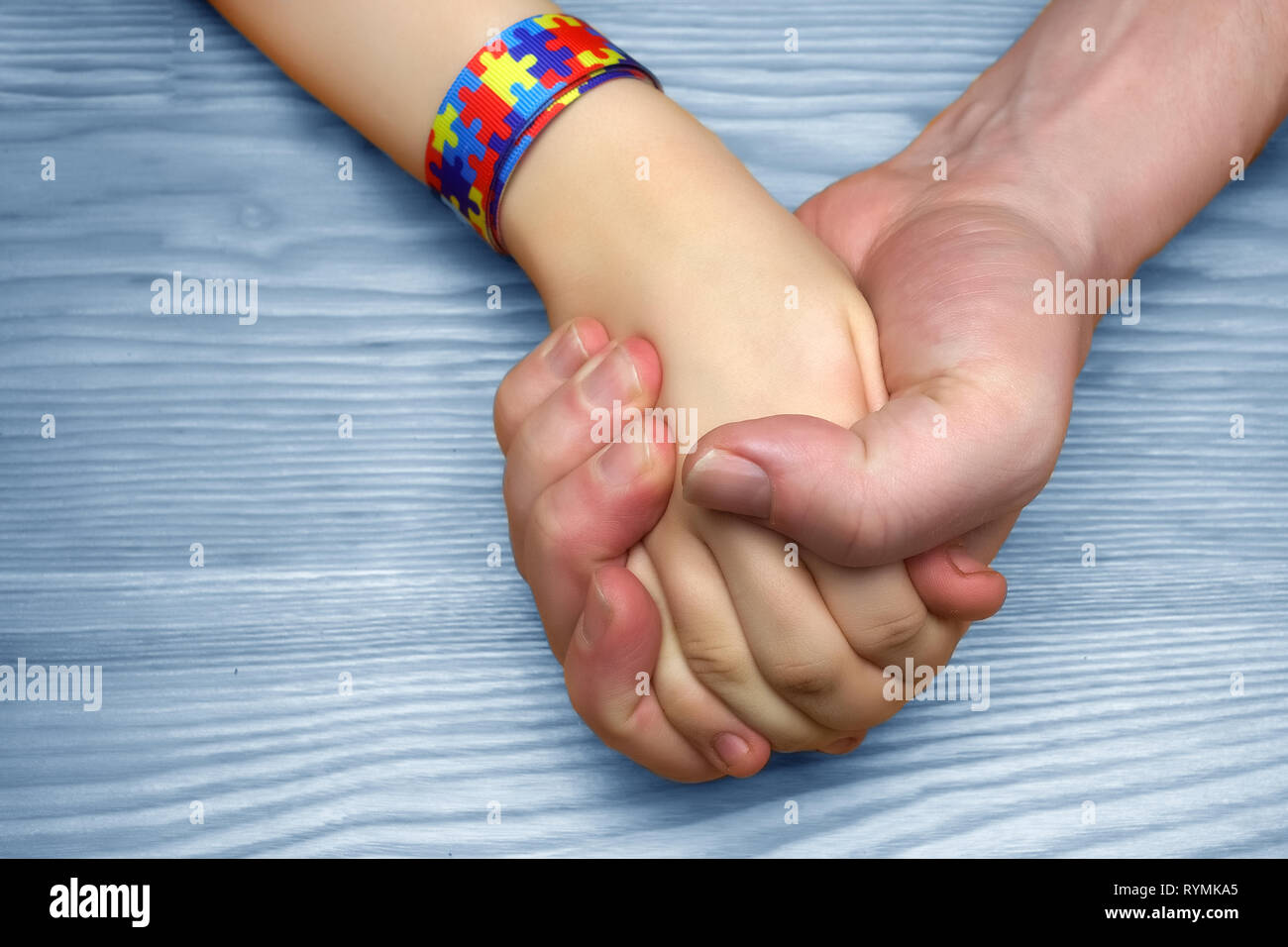 L'autismo consapevolezza dell'immagine. Padre tenendo la mano del suo bambino autistico Foto Stock