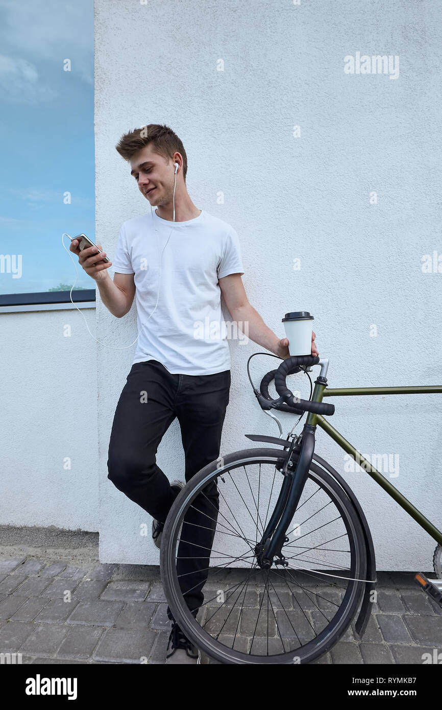 Bello hipster uomo in posa con la bicicletta in città. Foto Stock