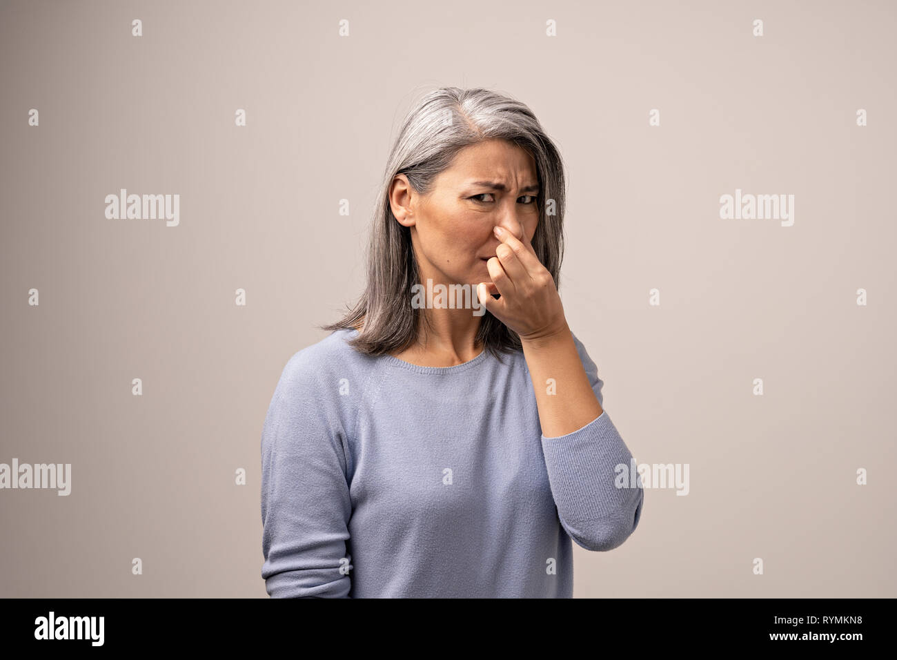 Coppia donna asiatica mentre tiene il suo naso a causa di un cattivo odore Foto Stock