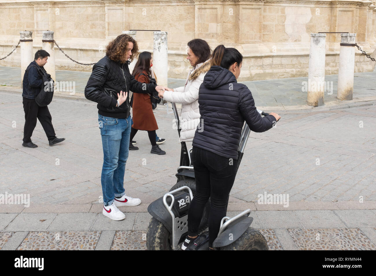 I turisti essendo mostrato come utilizzare Segway scooter in Plaza del Triunfo dalla Cattedrale di Siviglia Foto Stock