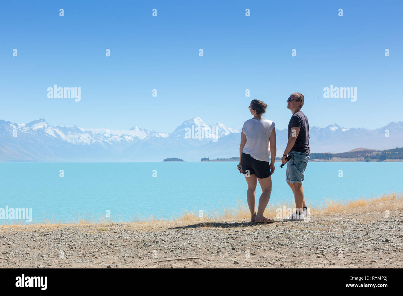 Due giovani godendo la vista Lago Pukaki, Nuova Zelanda Foto Stock