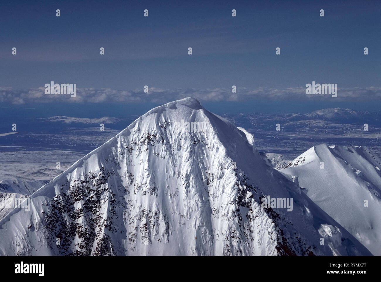 Questo close-up vista aerea mostra la snow-capped picco del maestoso Denali (ex Monte McKinley), che è la montagna più alta di America del Nord a 20,310 piedi (6,190 metri) e la principale attrazione del Parco Nazionale e Riserva di Denali in Alaska, Stati Uniti d'America. La montagna è stata ufficialmente dato indietro il suo originale' atabasco nome indiano da U.S. Il presidente Barack Obama nel 2015. Foto Stock
