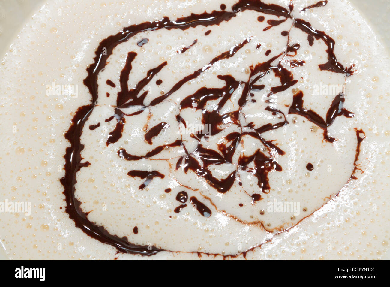 Raffreddata cioccolato fondente fuso versato in le uova sbattute con lo zucchero Foto Stock