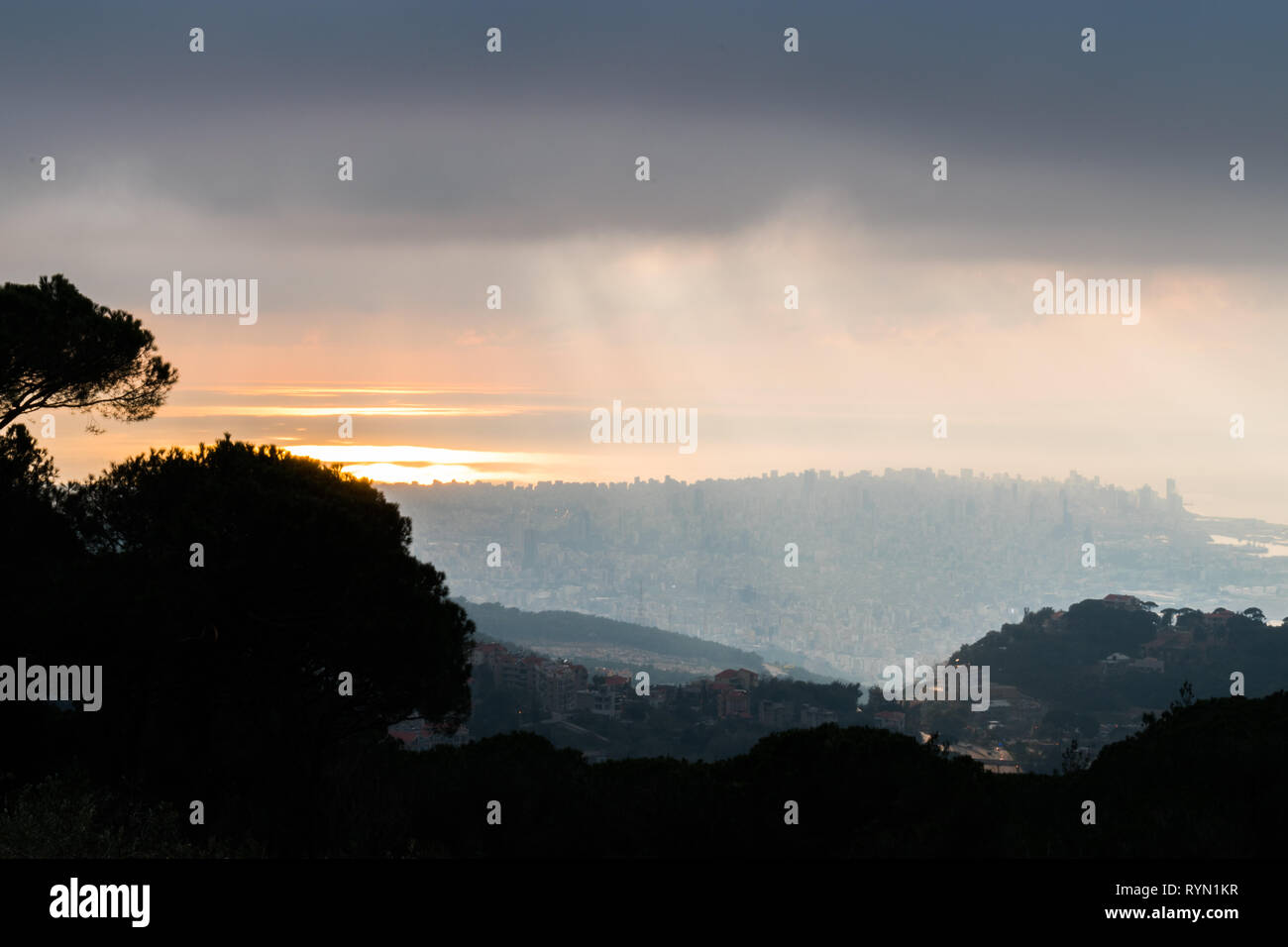 Questa è una cattura del tramonto a Beirut, capitale del Libano con un caldo colore arancione coperta con una nebbia pesante e qualche nuvola di pioggia Foto Stock