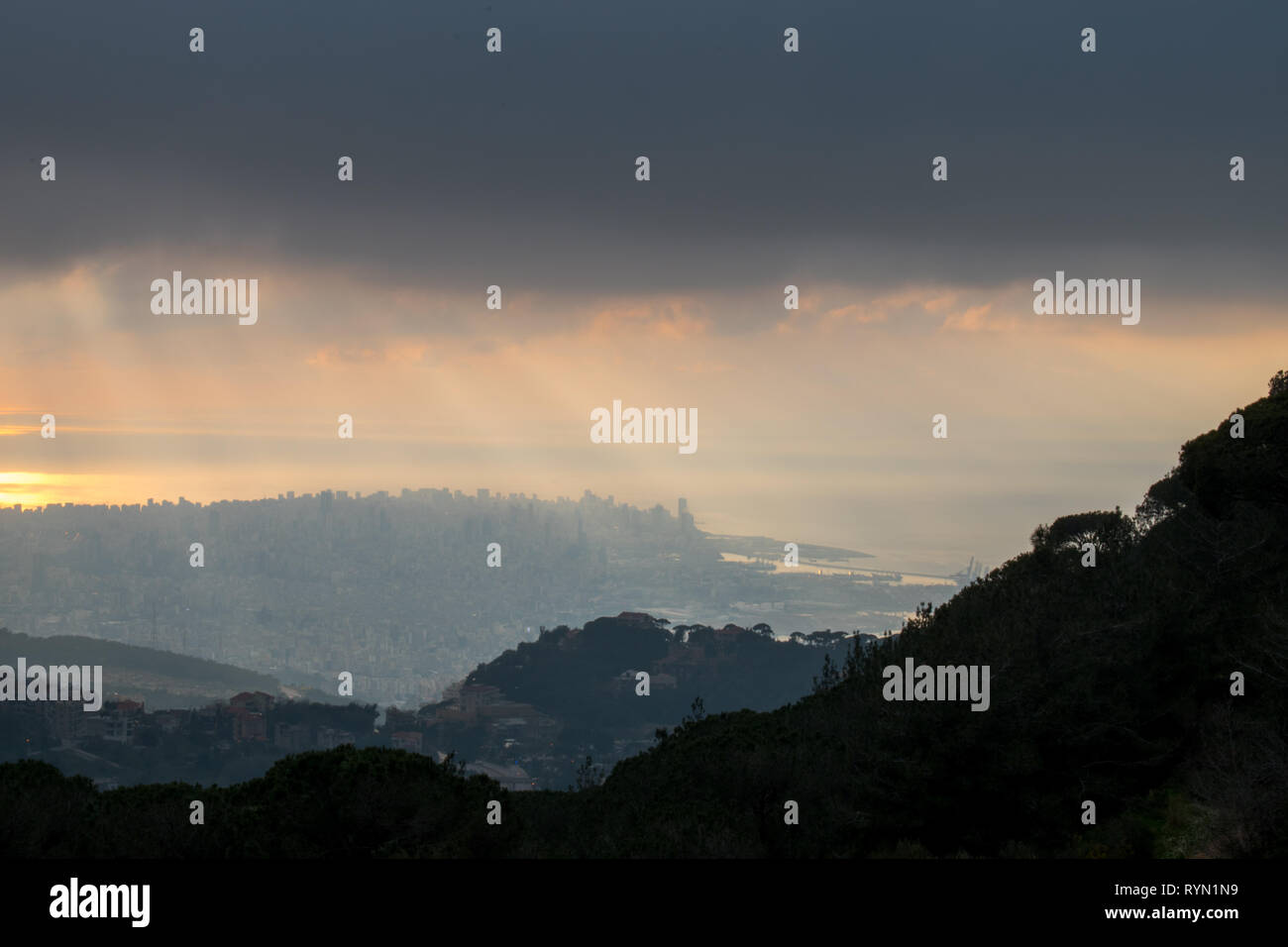 Questa è una cattura del tramonto a Beirut, capitale del Libano con un caldo colore arancione coperta con una nebbia pesante e qualche nuvola di pioggia Foto Stock