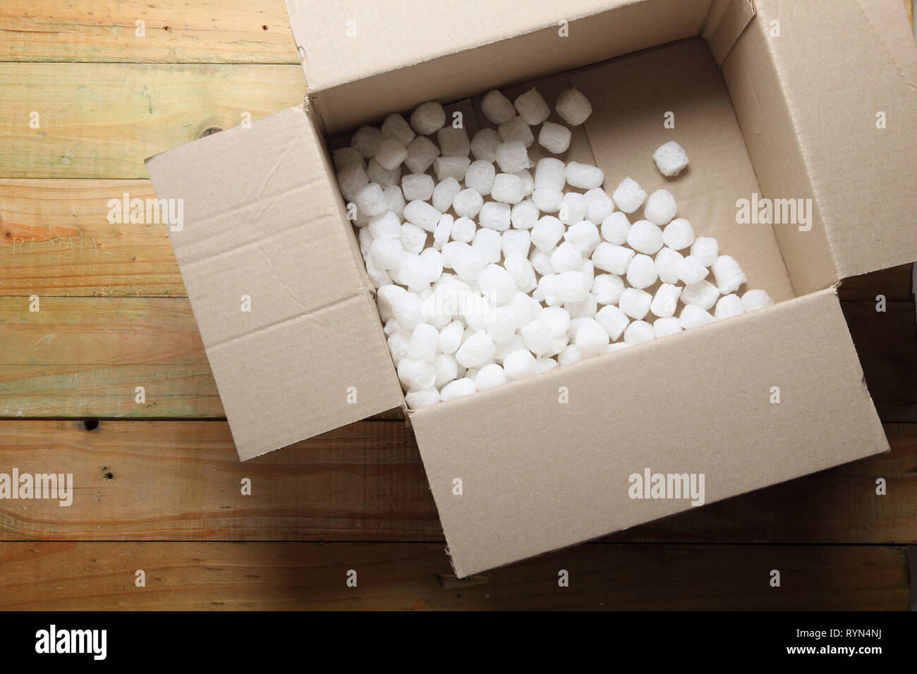 Scatola con Styrofoam su sfondo di legno Foto Stock