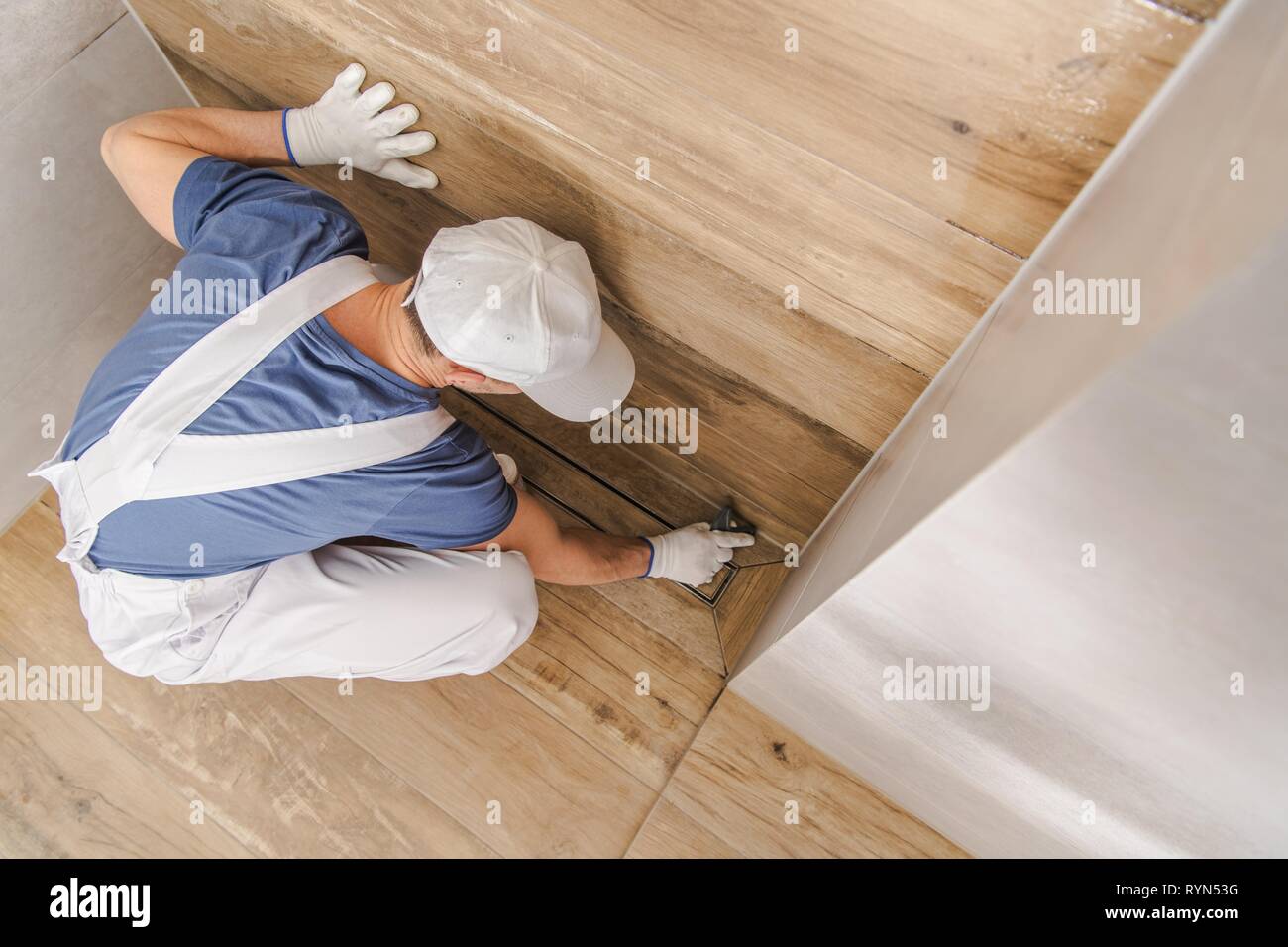 Lavoratore caucasica Intonacando e sigillatura di cabina doccia con silicone e boiacca. Bagno rimodellamento osseo. Foto Stock